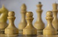 White wooden chessman, chess pieces stand on a chessboard in the