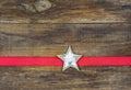 White wooden Christmas Star with red ribbon on wood background. Royalty Free Stock Photo