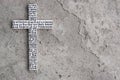 White wooden cross with the Lord`s prayer on the grey concrete with cracks background.