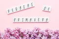 Wooden cubes with the sale spring in Spanish, Italian and Portuguese lilac branches on a pink background, seasonal concept