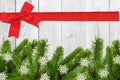 White wooden desk and red bow, ribbon and green christmas tree Royalty Free Stock Photo