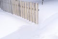 White wooden fence half covered with snow