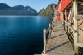 Wooden walk under red wooden fisherman`s house in Reine, Lofoten, Norway. Sunset of a sunny day in the village by the sea. Wooden Royalty Free Stock Photo