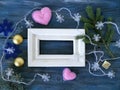 White wooden frame decorated with fir branches, Christmas-tree lighting with snowflakes, felt hearts on a blue wooden textural bac Royalty Free Stock Photo