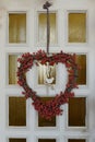 White wooden front door decorated in autumn, with red leaves, berries and a wreath Royalty Free Stock Photo