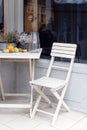 White wooden garden chair and table with beautiful flowers near the entrance to the house. Stock photo back yard with garden Royalty Free Stock Photo