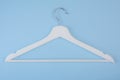 White wooden hanger isolated on blue background Royalty Free Stock Photo