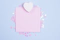 White wooden heart and pastel pink blank card mockup on pastel blue background with scattered pink glitter stars. Place for your