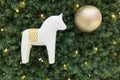 White wooden horse and golden decorative ball on the Christmas tree. Festive christmas background backdrop, christmas decoration. Royalty Free Stock Photo