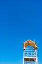 White wooden lifeboat tower on beach against sky