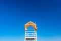 White wooden lifeboat tower on beach against sky