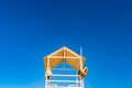 White wooden lifeboat tower on beach against sky