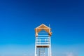 White wooden lifeboat tower on beach against sky