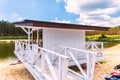 White, wooden lifeguard booth situated on sand beach next to the lake