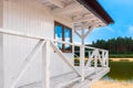 White, wooden lifeguard booth situated on sand beach next to the lake