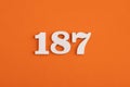 White wooden number 187 on eva rubber orange background