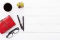 White wooden office desk table with blank notebook, calculator, coffee cup and other office supplies. Top view with copy space,