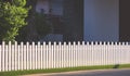 White wooden picket fence on artificial turf with sunlight and shadow on surface in front yard area at home Royalty Free Stock Photo