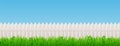 White wooden picket fence and green grass