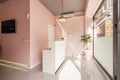 White wooden reception desk in a local beauty salon with pink walls and white marble floors