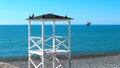 White, wooden rescue tower on the beach near the sea