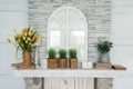 White wooden shelf with bouquet of tulips, grass in pot