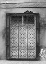 White wooden shuttered window behind wrought iron bars