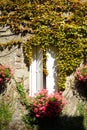 White wooden shutters in a stone house decorated with flowers Royalty Free Stock Photo