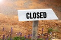 White wooden signpost with the word closed