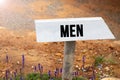 White wooden signpost with the word men