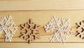 White and wooden snoflakes on wooden background.