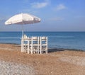 White wooden table on beach with blue sea with four chair Royalty Free Stock Photo