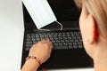 On a white table a black laptop with a medical mask on it Royalty Free Stock Photo