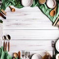 White wooden table covered with green tablecloth and cooking utensils. View from top Royalty Free Stock Photo