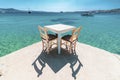 White wooden table with two chairs near the sea under the beautiful blue sky Royalty Free Stock Photo