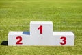 White wooden winner podium placed on green grass sport field on