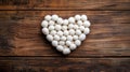 White wool balls arranged in a heart shape on wood Royalty Free Stock Photo