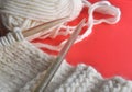 White wool knitting needles and handmade knits on bright orange background