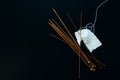 white wool knitting needles and a piece of knitting against a black background Royalty Free Stock Photo