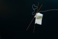 white wool knitting needles and a piece of knitting against a black background Royalty Free Stock Photo