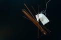 white wool knitting needles and a piece of knitting against a black background Royalty Free Stock Photo