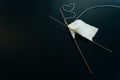 white wool knitting needles and a piece of knitting against a black background Royalty Free Stock Photo