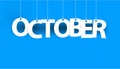 White word OCTOBER - word hanging on the ropes on blue background. Royalty Free Stock Photo