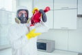 White worker spraying pesticide on induction hob Royalty Free Stock Photo