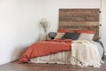 White worm blanket on dirty orange duvet on king size bed