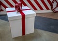 White wrapped present box with red bow tie against concrete back Royalty Free Stock Photo