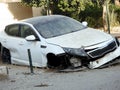 white wrecked car damaged by accident on the road which crashed with another car until it was demolished Royalty Free Stock Photo