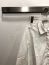 White wrinkled, not ironed shirt hanging on a trempel