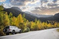 White 4x4 car traveling along a autumn mountains road Royalty Free Stock Photo
