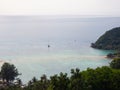 White yacht floating in the turquoise sea to the island with clouds